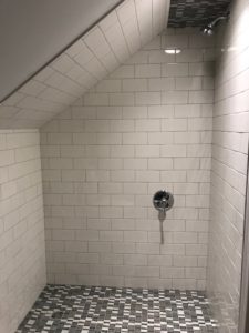 Remodeled tile shower with a graded tile ceiling.